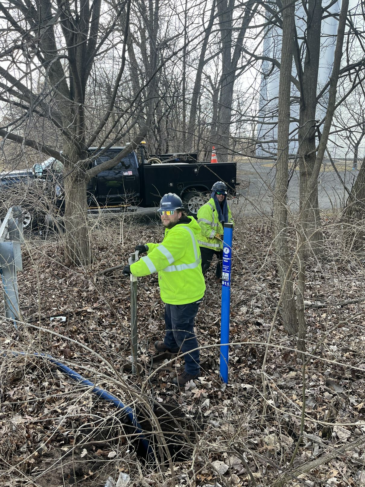 2 people in autumn in overgrown area turning valves